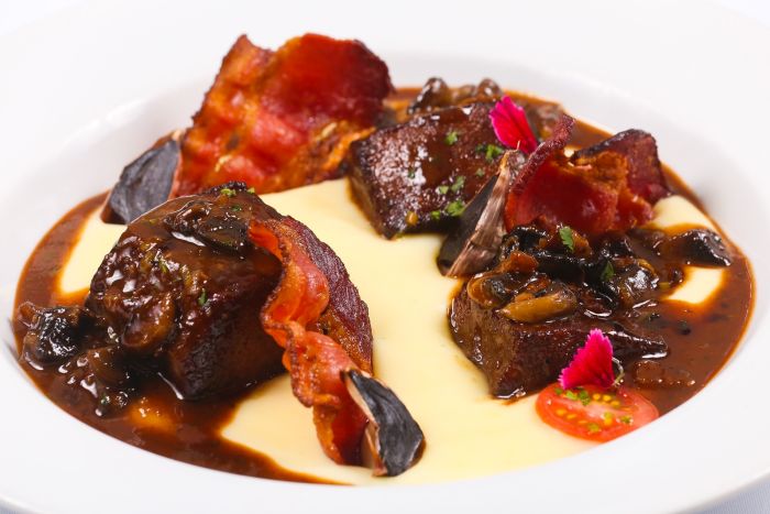 Língua bovina com molho de cogumelos, musseline de batata, bacon crocante e alho negro - Foto: Divulgação